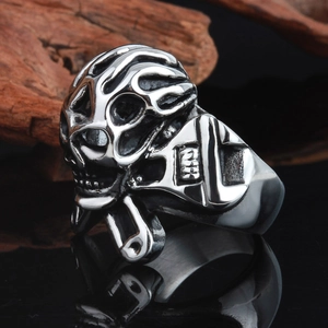 Punk rocker skull ring with flame patterns and silver vintage finish on a dark base