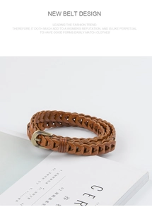 Close-up of a vintage dark brown braided waist belt with an antique bronze metal buckle