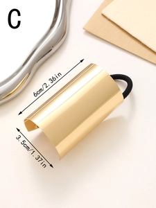 Detail view of golden geometric hair tie with size markings of 6cm length and 3.5cm width