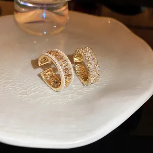 Elegant gold open rings with hollow pearl design and square zircon inlay on ceramic tray