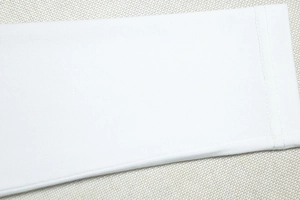 Detail shot of the double-needle sleeve hem on the white elegant bodycon dress