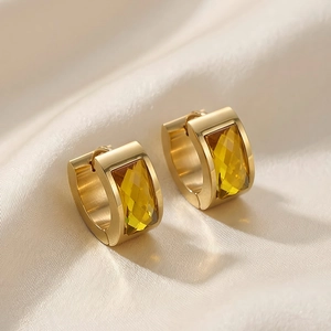 Detailed macro view of gold-plated stainless steel earrings with rectangle yellow stones