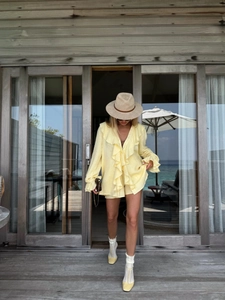 Ensemble chic jaune avec gilet à volants et short pour un style de vacances élégant