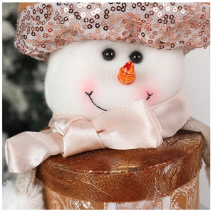 Primo piano di un pupazzo di neve natalizio con cappello di paillettes e sciarpa rosa