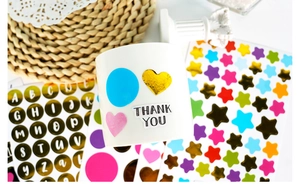 Close-up of golden heart and star stickers applied to a white ceramic mug for DIY decoration