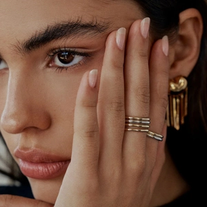 Minimalist gold and silver stainless steel rings layered with elegant tassel earrings