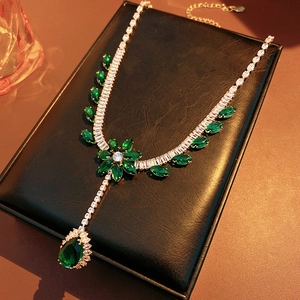 Close-up of flower pendant with emerald green gemstones and sparkling cubic zirconia