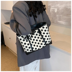 Polka dot tote bag on shoulder showing large capacity and stylish contrast piping