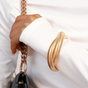 Close-up of a gold multi-layer spiral cuff bracelet with textured metallic surface
