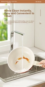 Water flowing over red non-stick frying pan with detachable handle in a kitchen sink