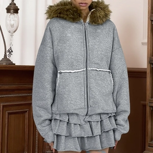 Détail d'un sweat à capuche gris avec bordure en fausse fourrure et jupe à volants