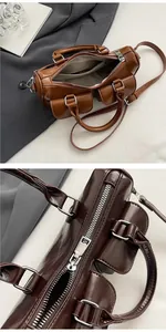 Macro view of brown vintage cylindrical saddle bag showing internal lining and metal zipper
