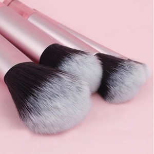 Close-up of pink metallic makeup brushes with soft black and white gradient bristles
