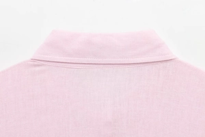Close-up of pink shirt collar showing high-quality fabric texture and neat stitching