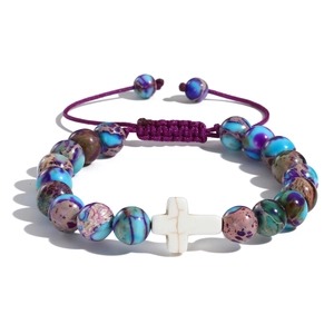 Dettaglio del bracciale pasquale con perline, croce bianca e cordino viola intrecciato
