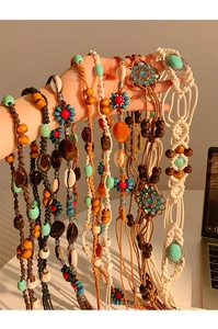 Détail d'une chaîne de taille bohème tressée à la main avec perles et coquillages
