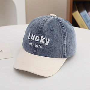 Detail of vintage washed denim kids cap featuring Lucky embroidery and color block brim