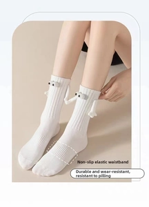 Detail view of white crew socks featuring 3D monster eyes and magnetic hands