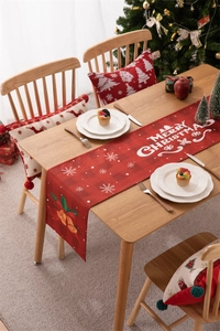 Close-up of red Christmas table runner with Merry Christmas text and festive patterns