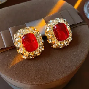 Vintage gold-toned oval red stone stud earrings surrounded by sparkling crystals