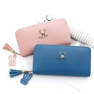 Detail of long wallet zipper with gold bear ornament, tassel and rabbit charm detail