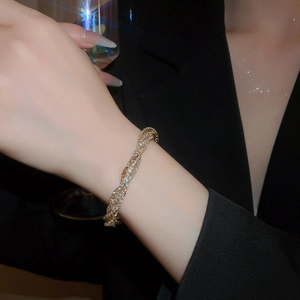 Detail of elegant gold multi-layer twisted bracelet with sparkling rhinestones on model
