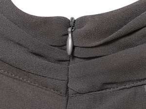Detailopname van een donkergrijze blinde rits op een geplooide mesh jurk voor dames