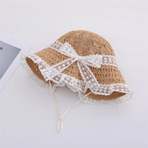 Detailed view of kids straw sun hat featuring lace trim, bow, and adjustable chin strap