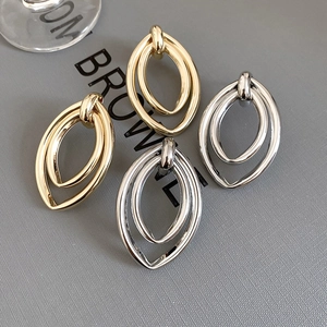 Détail de boucles d'oreilles ovales doubles couches en finitions or et argent polis