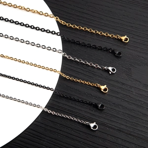 Close-up of minimalist O-chain necklaces in gold, black, and silver with lobster clasps