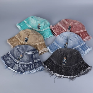 Detail of embroidered teddy bear patterns on six colors of frayed denim bucket hats