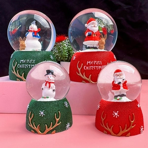 Detailed view of four Santa and Snowman crystal snow globes with Merry Christmas bases