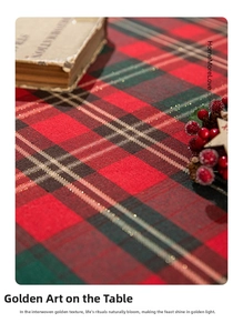 Close-up of red and green plaid Christmas tablecloth with glittery gold thread weaving
