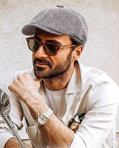 Detailed view of gray linen newsboy cap worn by male model for casual retro aesthetic