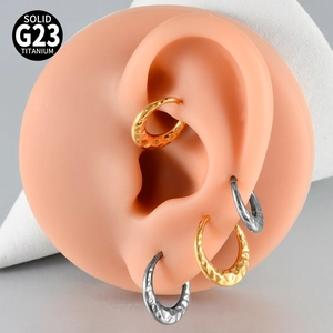 Detail of G23 titanium hoop earrings showing textured finish on silicone ear model