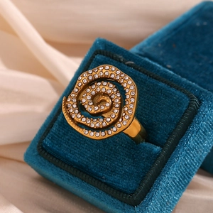Detailed view of gold spiral flower ring with cubic zirconia in a blue velvet box
