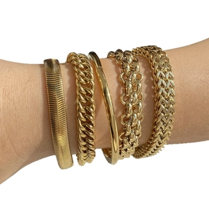 Five pieces set of gold vacuum plated stainless steel chain bracelets on female model wrist