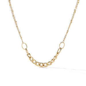 Close-up of double-layered gold necklace featuring beaded chain and flat oval link chain