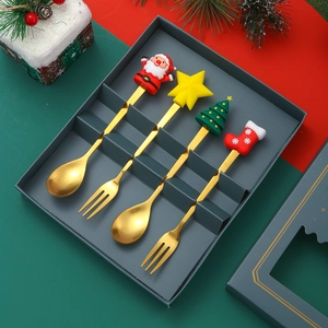 Golden Christmas cutlery set with cartoon charms in a green gift box with festive decor