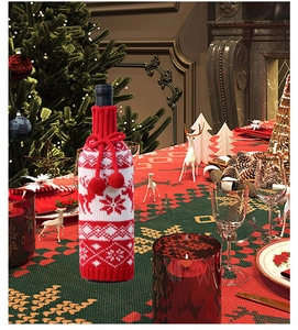 Close-up of knitted Christmas wine bottle cover with red and white elk snowflake patterns