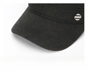 Détail de la visière renforcée et du tissu texturé fin sur la casquette d'hiver plate