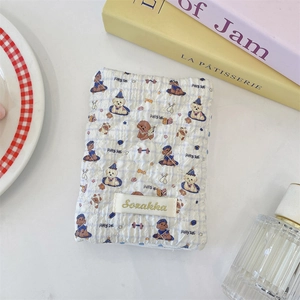 Detail of light blue quilted passport holder featuring a cute puppy print and fabric label