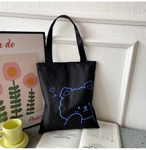 Close-up of black Oxford cloth tote bag with blue bear pattern in a lifestyle setting