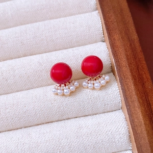 Macro detail of red bead earrings with 18k gold plated fan-shaped pearl accents