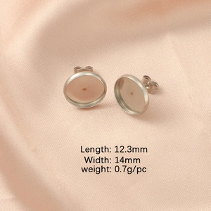 Macro shot of 12mm stainless steel stud earring bases with size specs on silk fabric