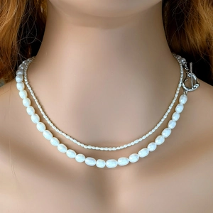 Detail of double-layer natural pearl necklace with silver heart OT clasp on neck