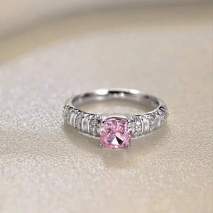 Detailed macro view of a pink cushion-cut zircon ring with paved silver accents