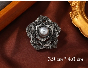 Macro shot of vintage rose brooch with black rhinestones and pearl detail, 3.9cm size