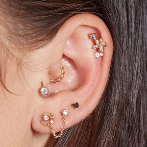 Detailed view of S925 silver gold-plated ear piercings with star, moon and butterfly studs