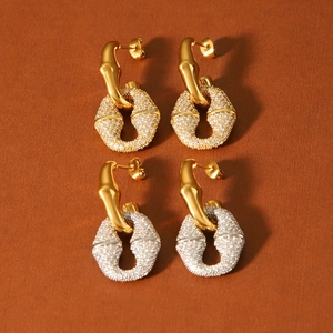 Detail showing two pairs of gold stainless steel hoop earrings with micro-pave crystals